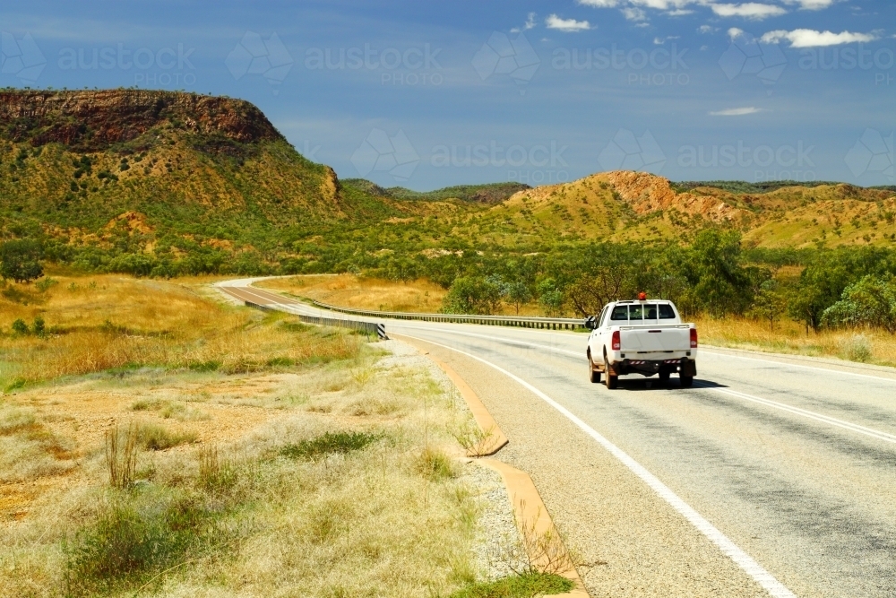 A white ute driving on  the Great Northern Highway in the Kimberley region - Australian Stock Image