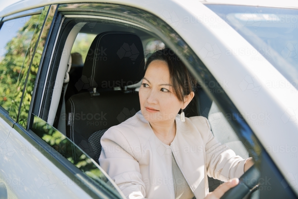A woman driving to work on a suv car - Australian Stock Image