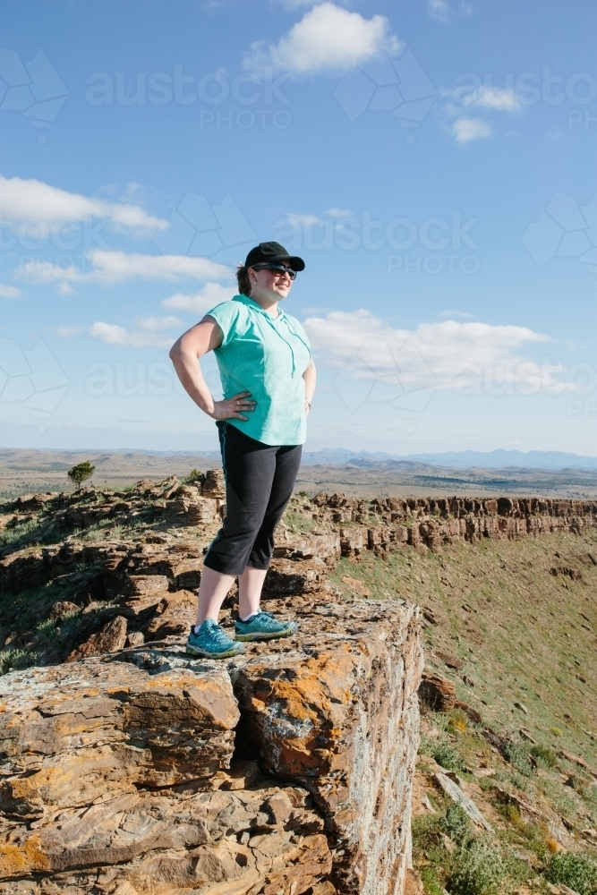 A woman in hiking gear overlooking the rugged landscape of the Flinders Ranges - Australian Stock Image