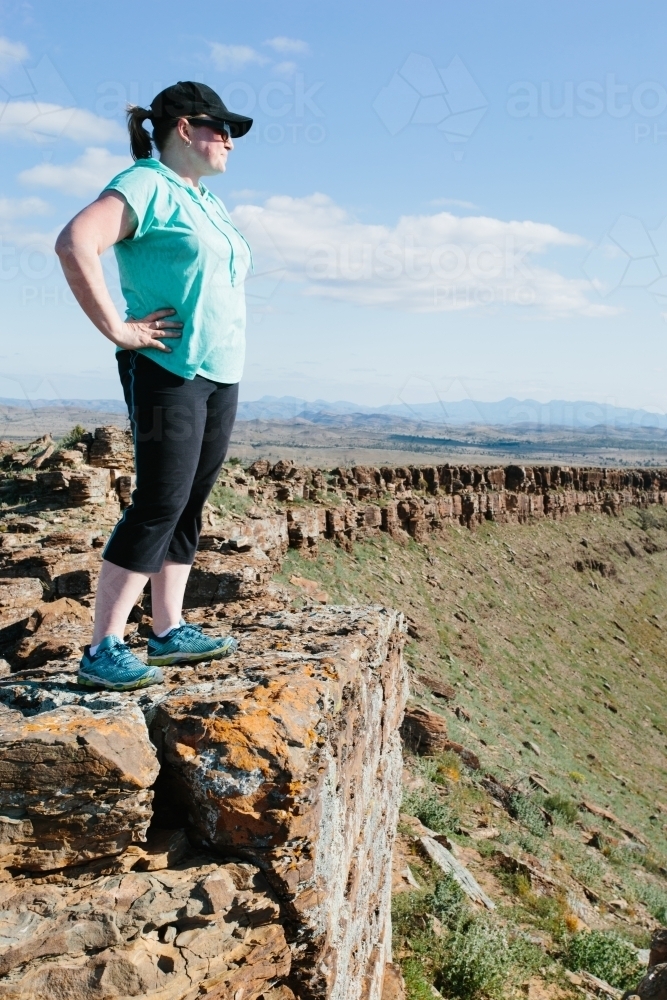 A woman in hiking gear overlooking the rugged landscape of the Flinders Ranges - Australian Stock Image