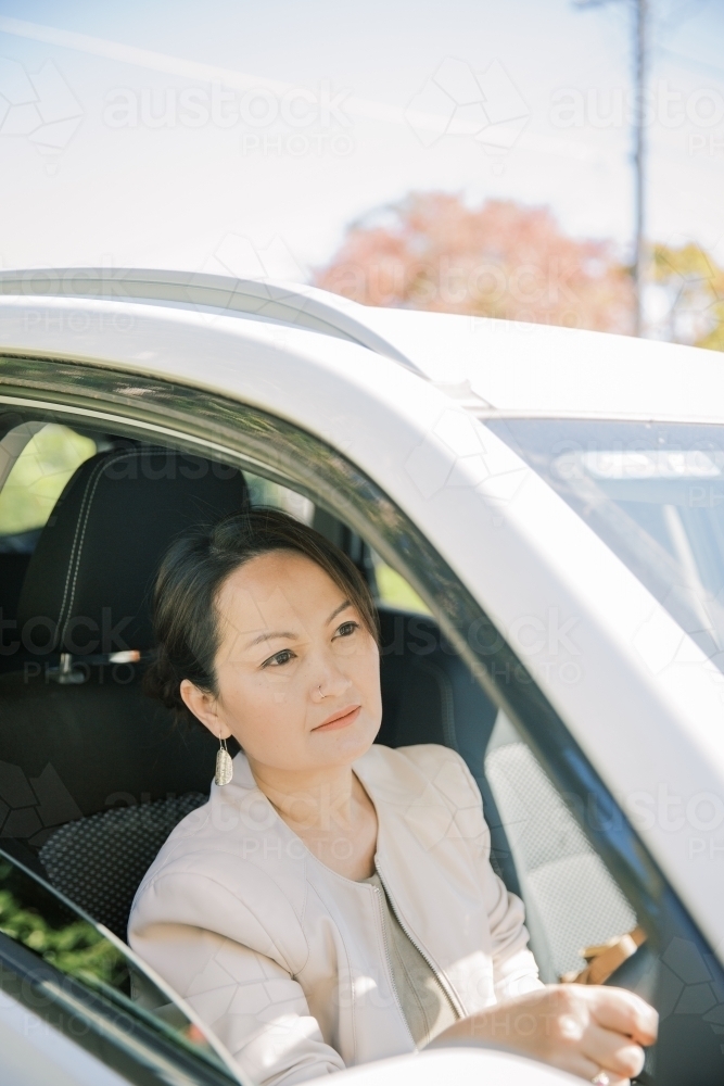 A woman sitting behind the wheels driving to work - Australian Stock Image