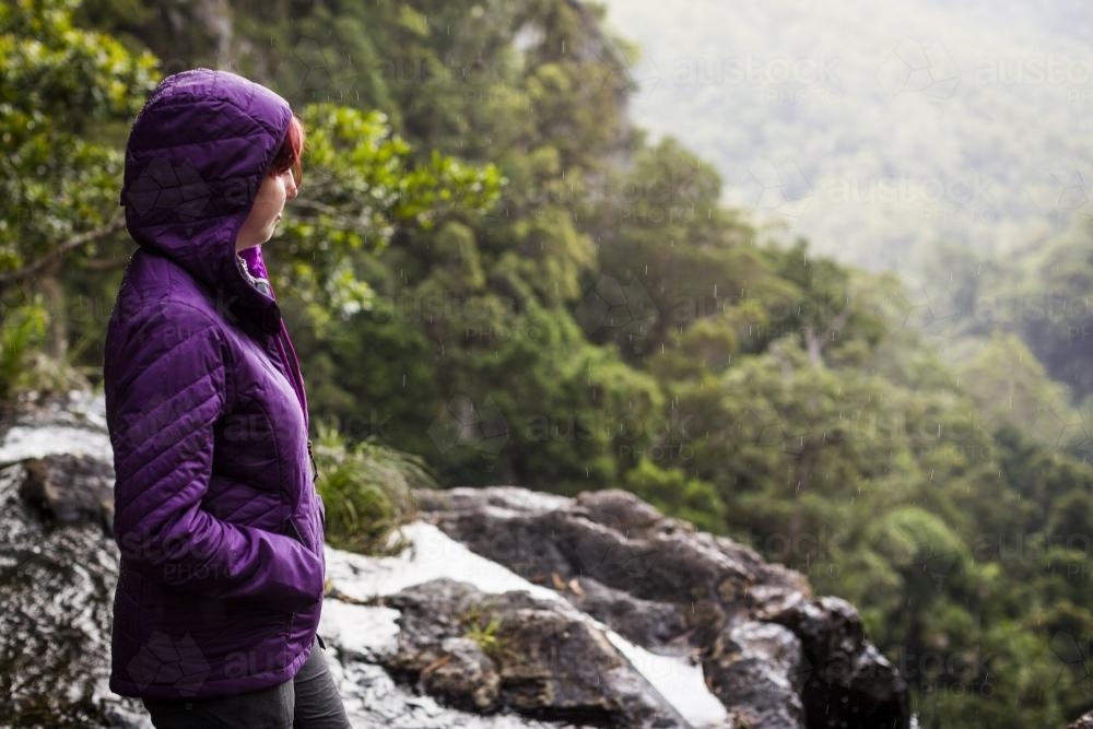 A woman standing by a waterfall - Australian Stock Image
