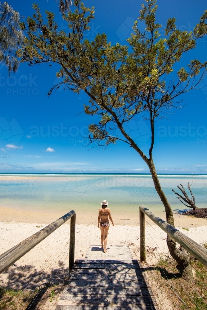 A woman walks out onto a deserted beach on Moreton Island - Australian Stock Image