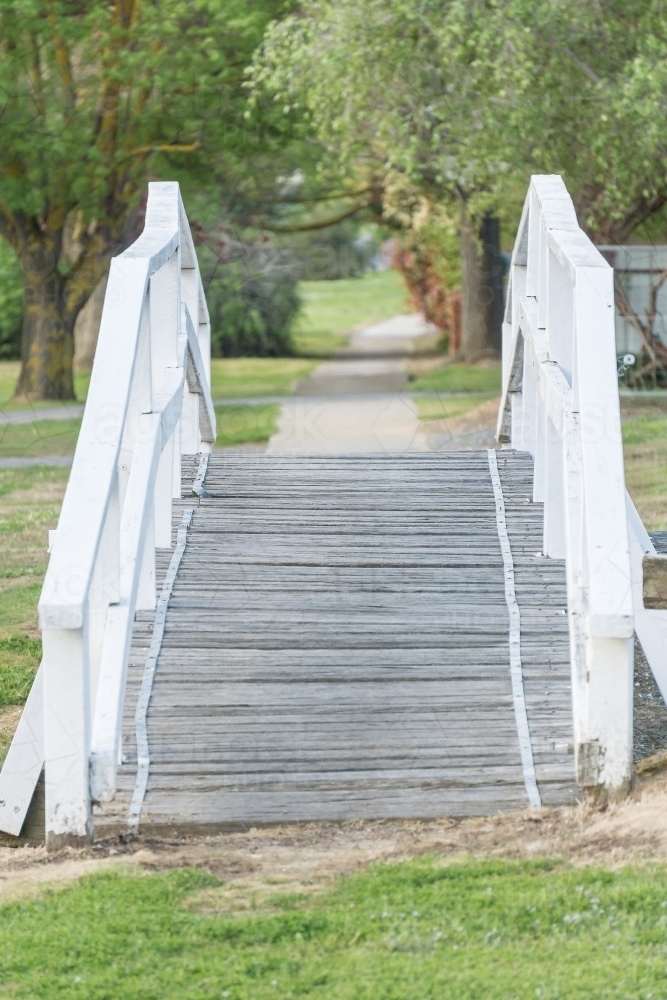 A wooden foot bridge leading onto a footpath. - Australian Stock Image