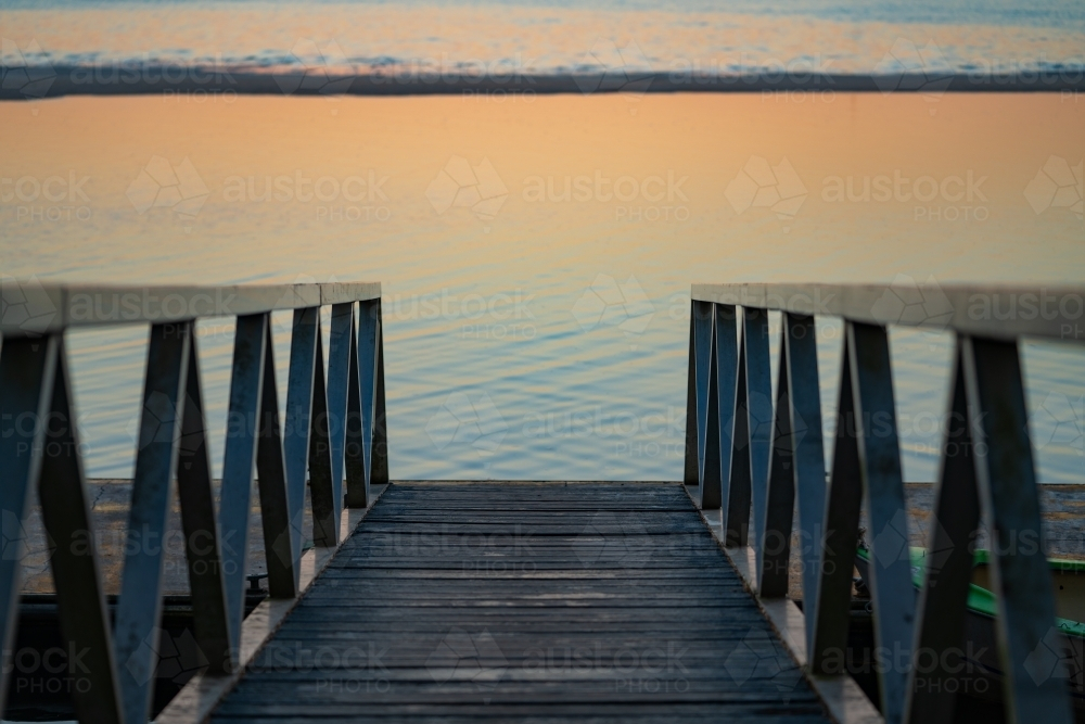 A wooden pier extending out to the ocean - Australian Stock Image