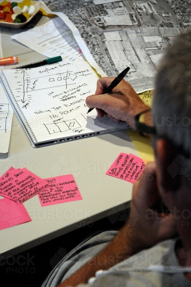 A workshop participant putting his ideas on paper - Australian Stock Image
