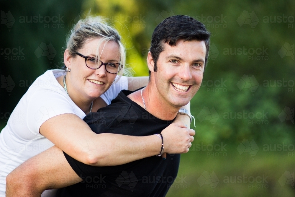 A young couple standing together outside looking at camera - Australian Stock Image
