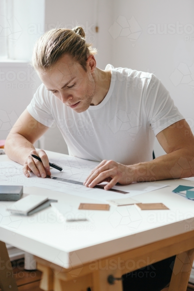 A young creative designer hard at work in a bright office space - Australian Stock Image