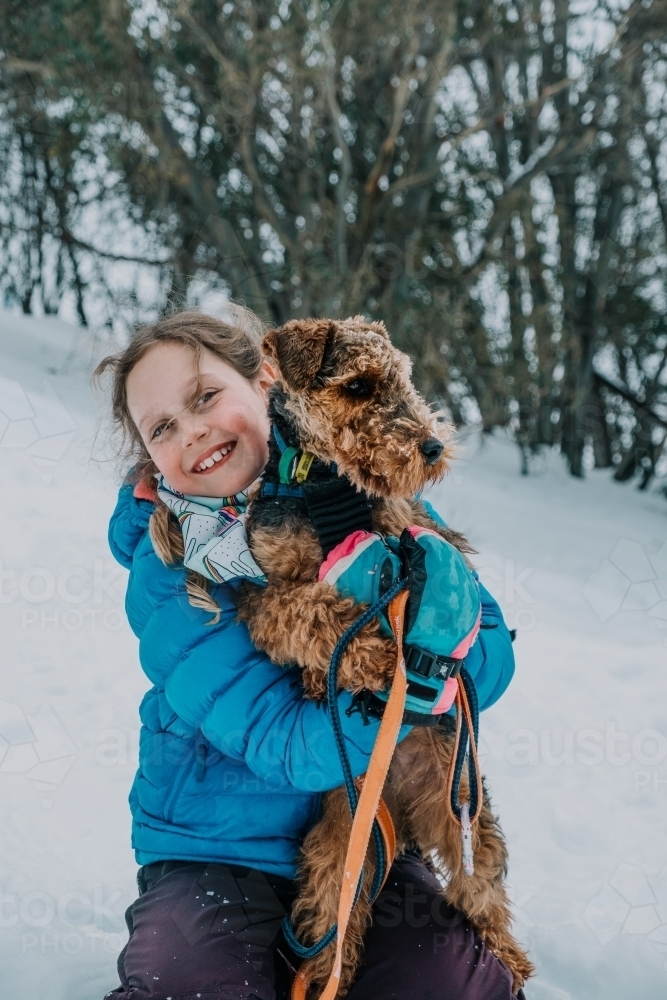 A  young girl and her dog at the snow. - Australian Stock Image