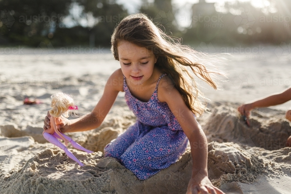 A young girl at the beach playing in the sand - Australian Stock Image