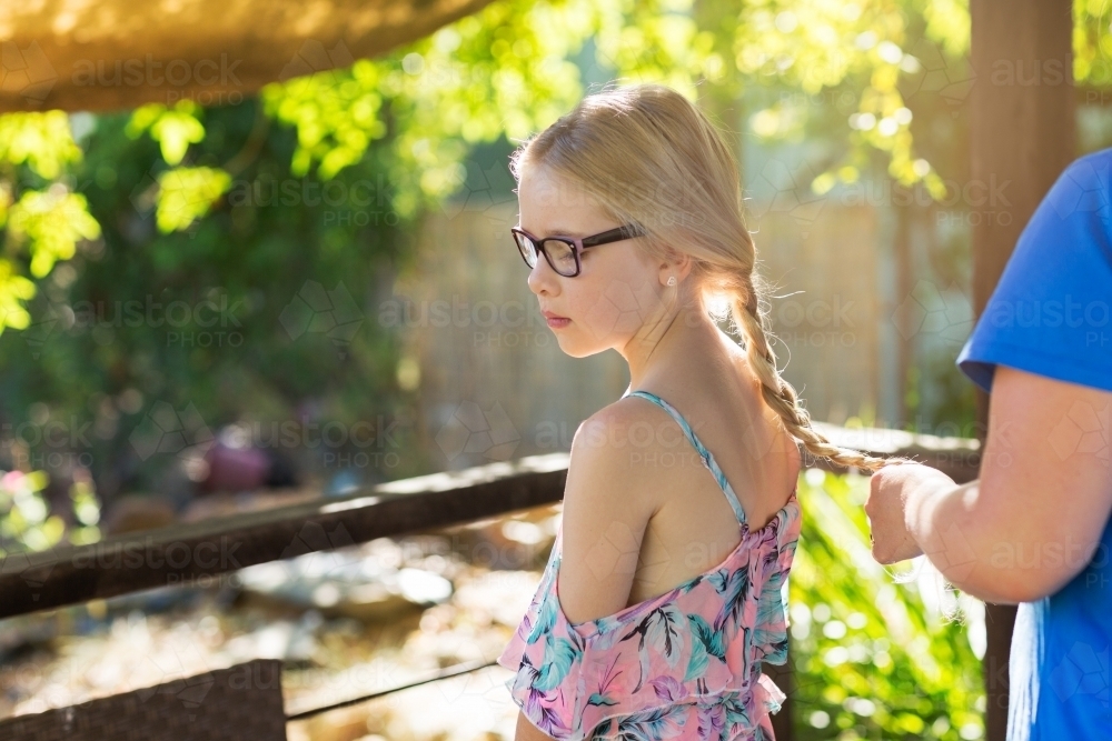 A young girl having her hair plaited - Australian Stock Image