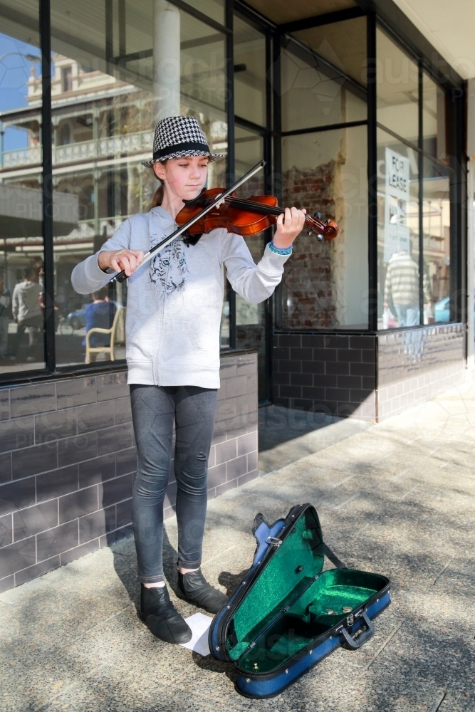 A young girl in her early teens busking with a violin. - Australian Stock Image