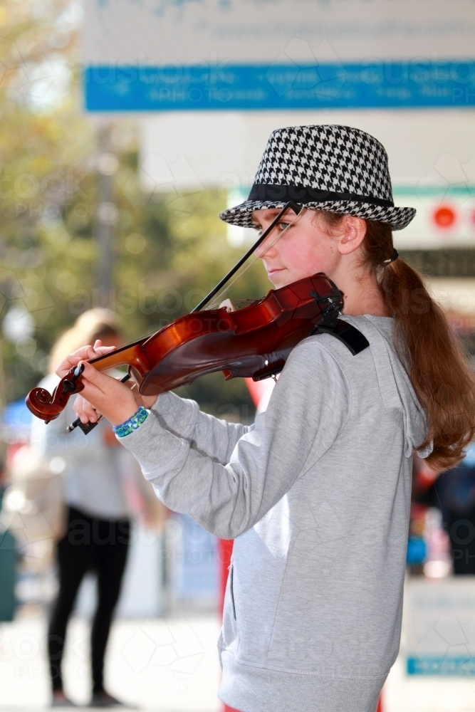 A young girl in her early teens busking with a violin. - Australian Stock Image