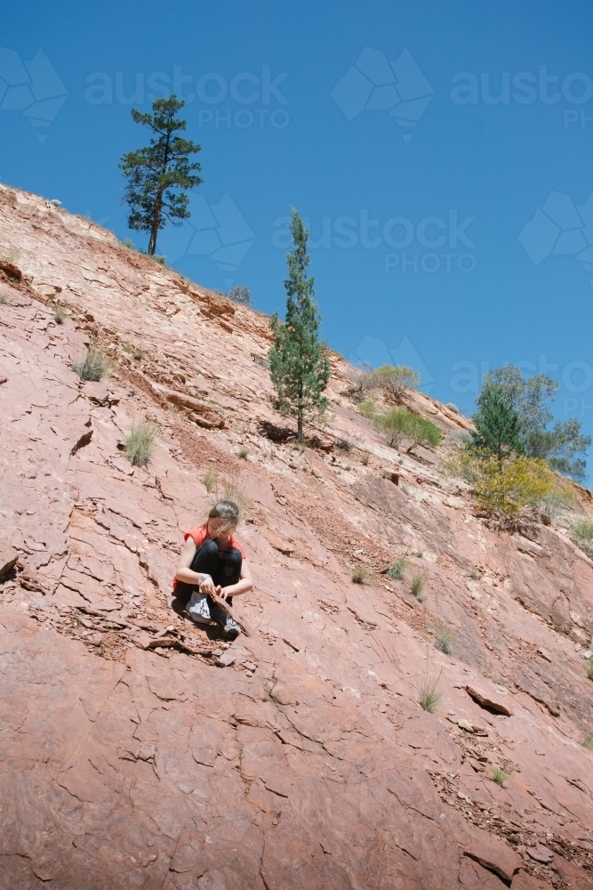 A young girl looking for fossils among rocks - Australian Stock Image