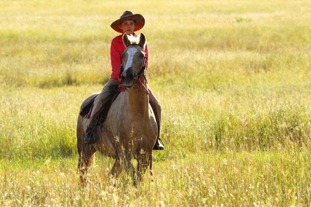 A young ten year old country girl and her horse pause during mustering - Australian Stock Image