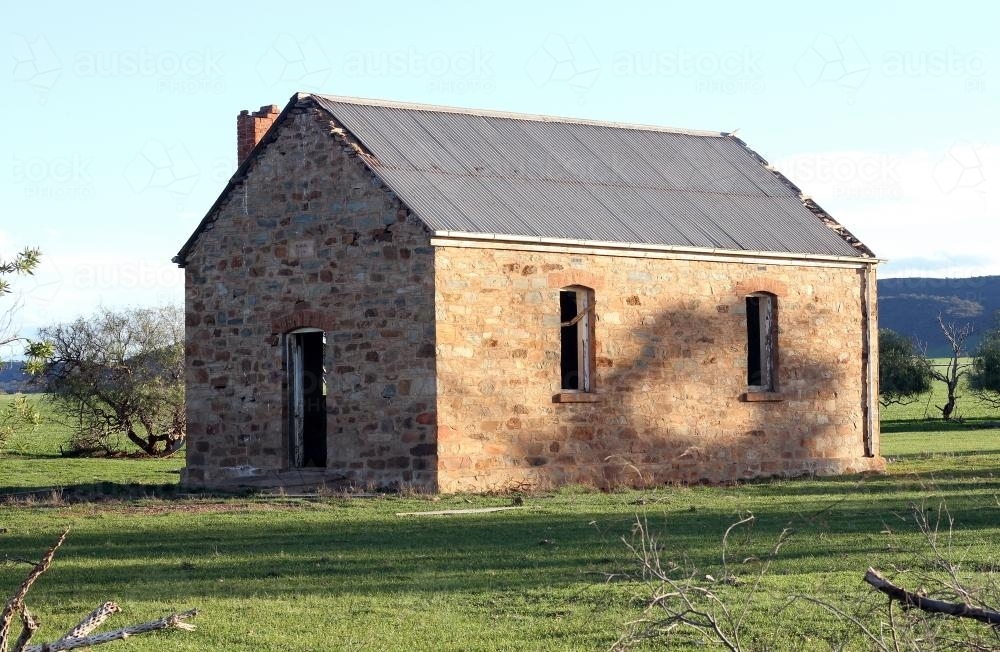 Abandoned brick building in a green paddock - Australian Stock Image