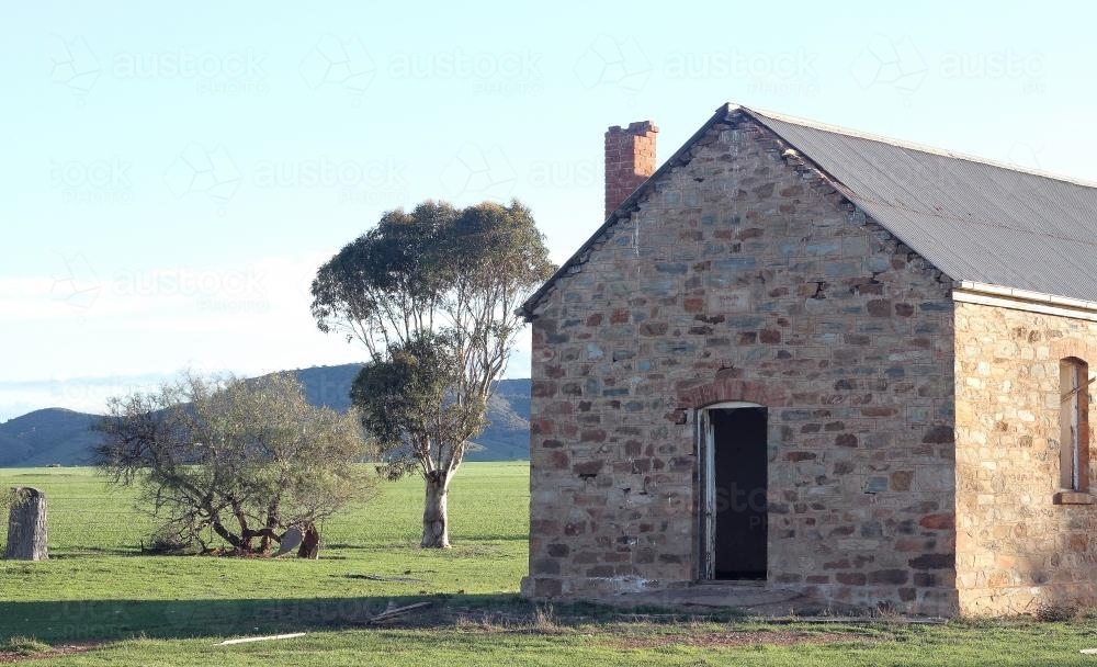 Abandoned brick building in a green paddock - Australian Stock Image