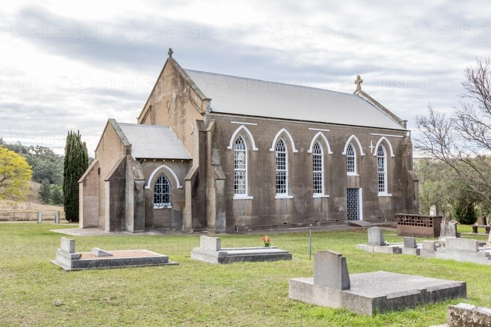 Abandoned grey country church and graveyard - Australian Stock Image