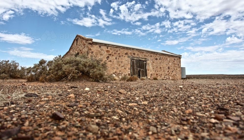 Abandoned sandstone dwelling on barren, rocky landscape in Flinders Ranges - Australian Stock Image
