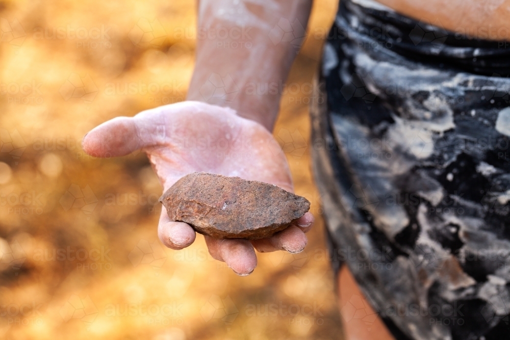 Aboriginal artefact axe head stone for cutting held in hand - Australian Stock Image