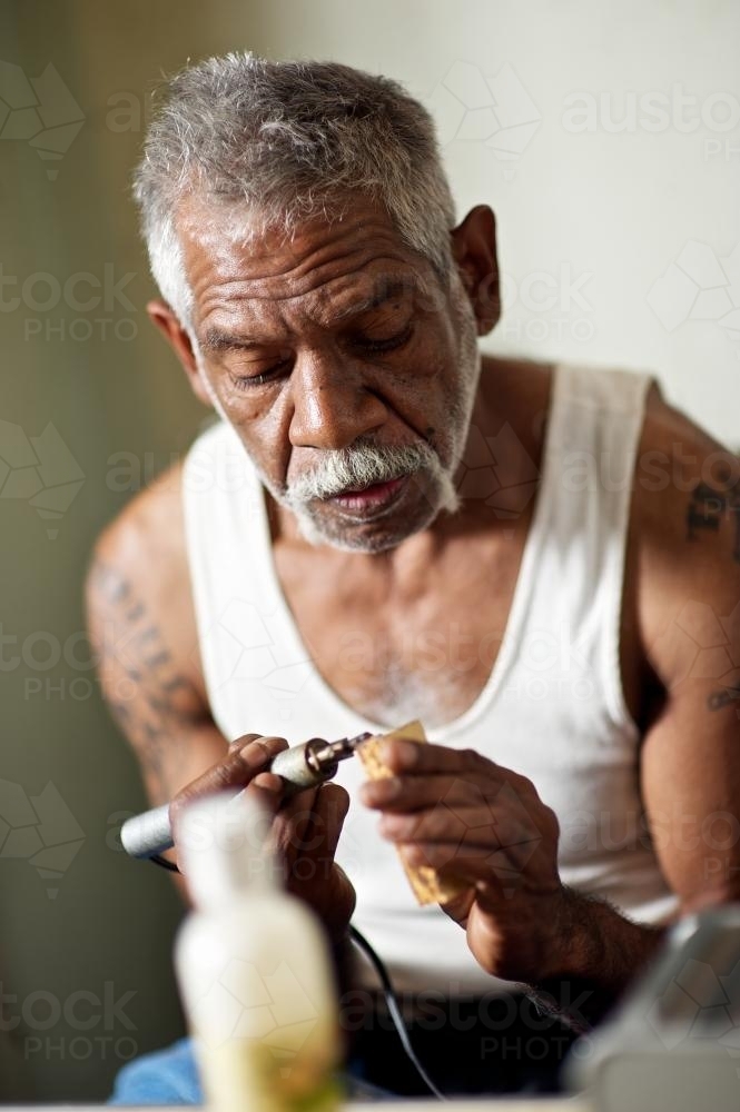 Aboriginal Artist at Work on Message Stick - Australian Stock Image