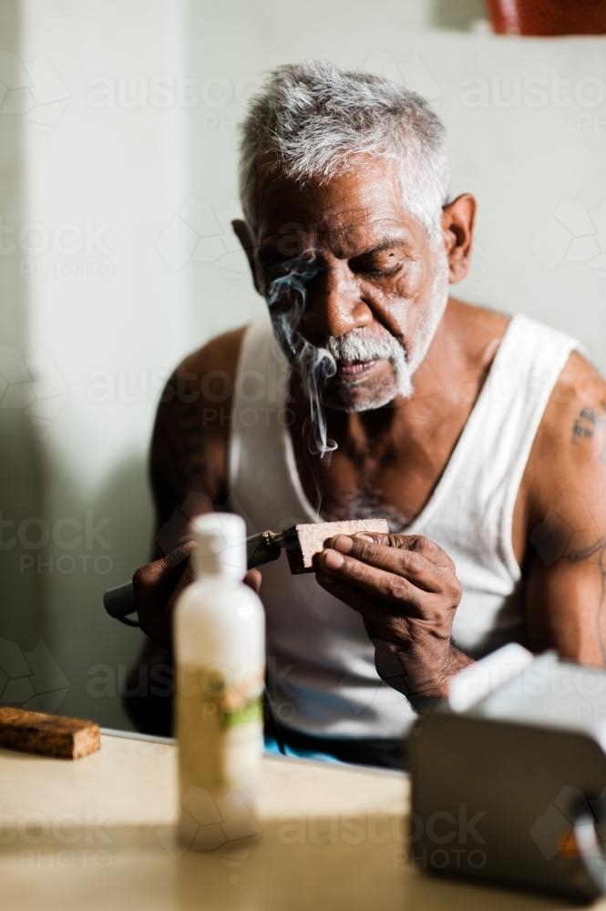 Aboriginal Artist at Work with a Wood Burner - Australian Stock Image