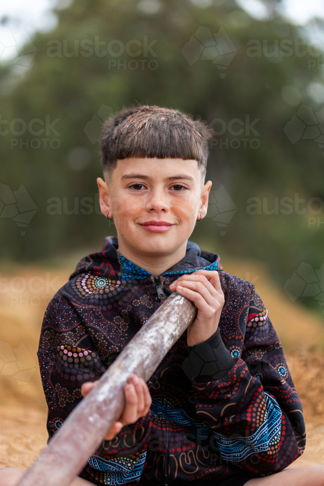 Aboriginal Australian boy holding didgeridoo ready to play on country - Australian Stock Image