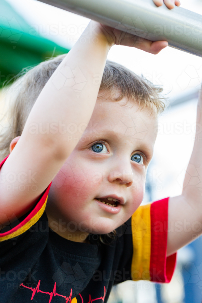 Aboriginal Australian boy with blue eyes playing at playground - Australian Stock Image