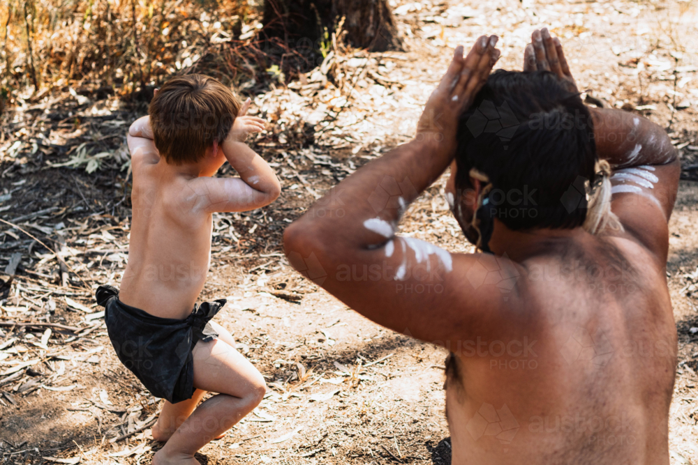 Aboriginal Australian father teaching his child cultural dance - Australian Stock Image