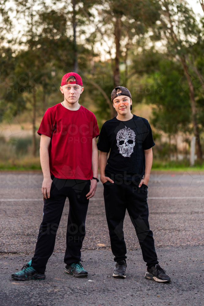 Aboriginal Australian teenaged cousins standing beside road together - Australian Stock Image