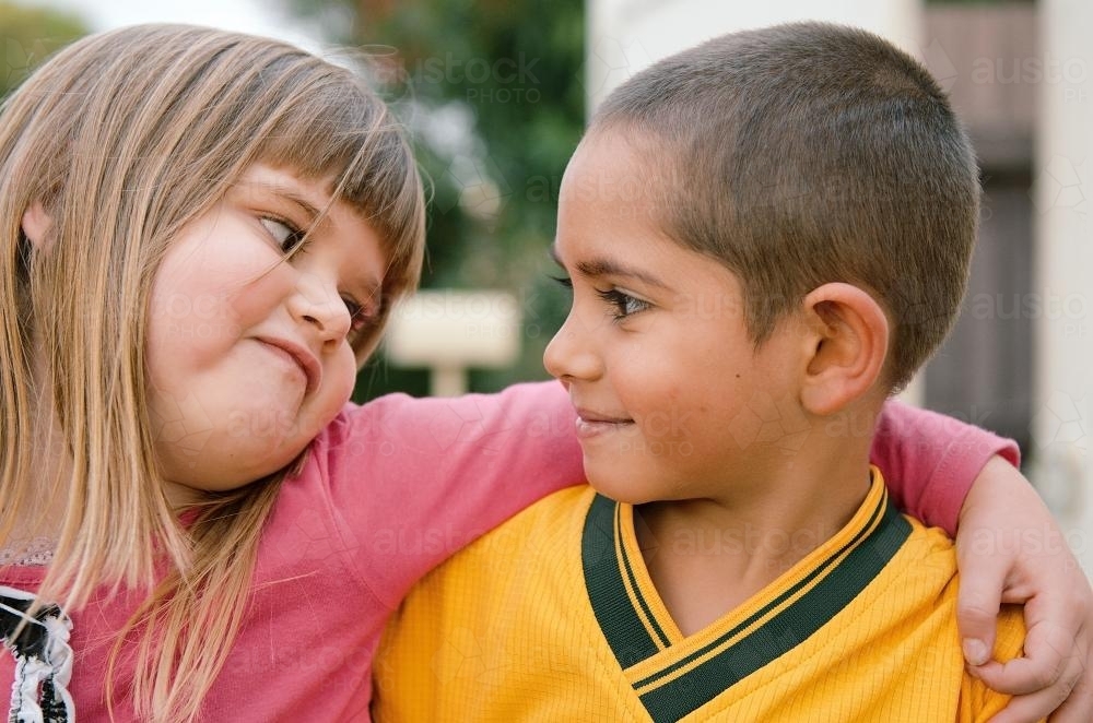 Aboriginal Boy and Caucasian Girl Looking at Each Other - Australian Stock Image