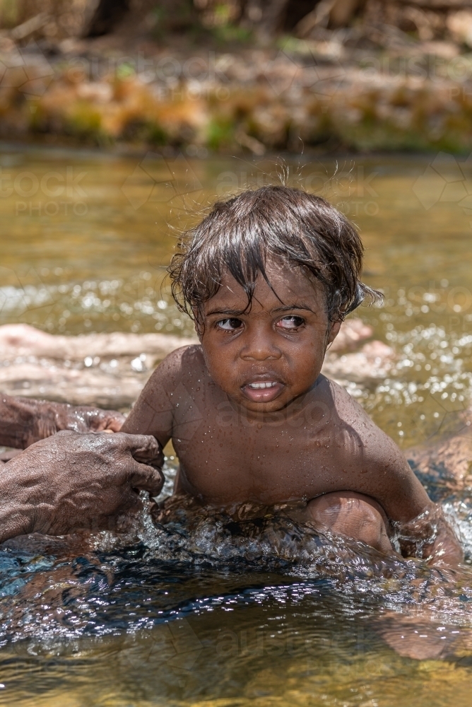 Aboriginal boy in a river - Australian Stock Image
