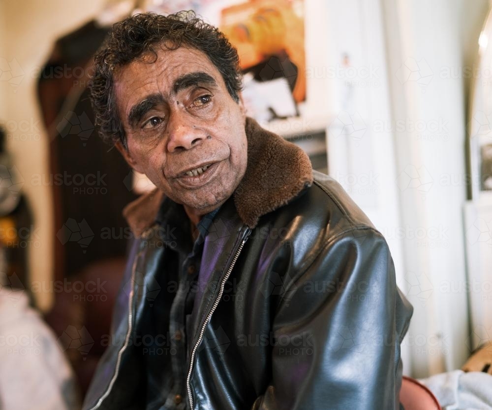 Aboriginal Elder inside a house looking off to the side - Australian Stock Image