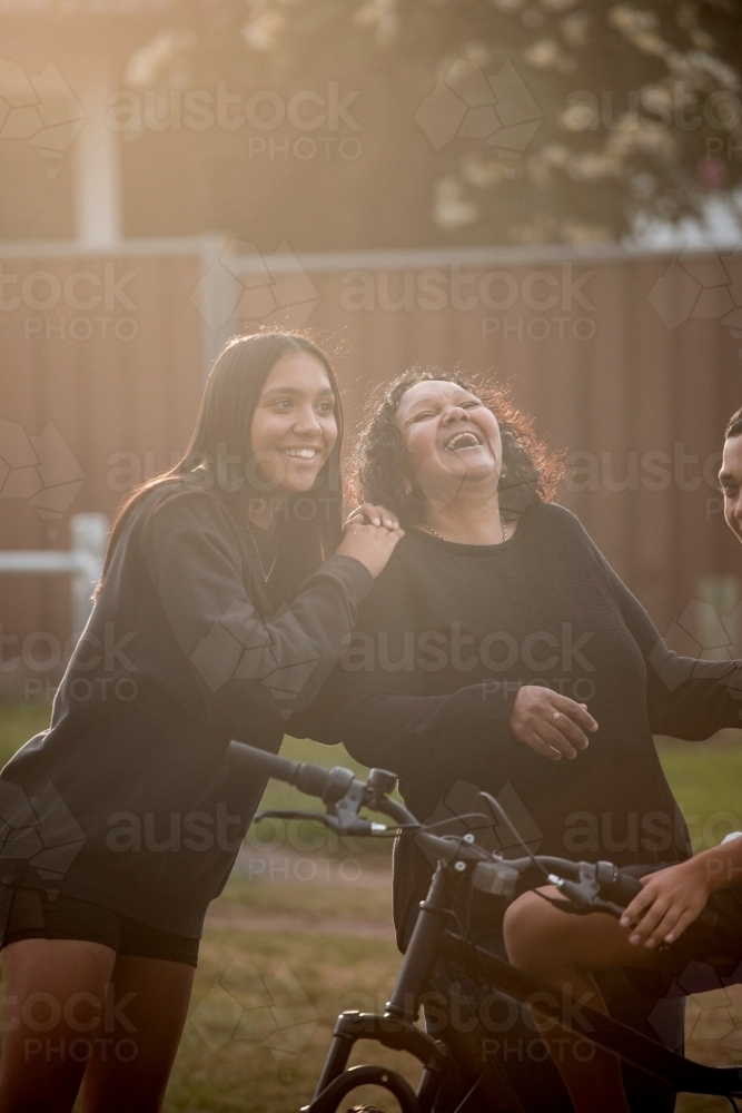 Aboriginal family in backyard mother and daughter laughing - Australian Stock Image