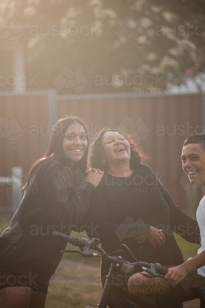 Aboriginal family laughing in backyard - Australian Stock Image