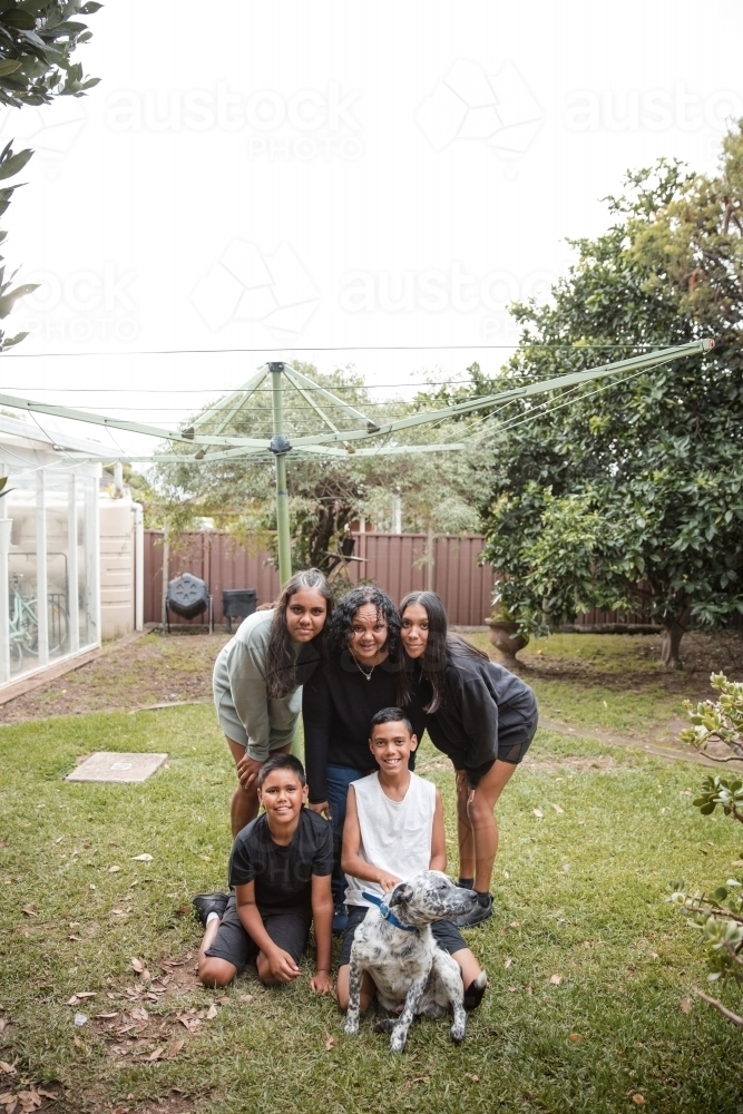 Aboriginal family photo with dog in backyard - Australian Stock Image