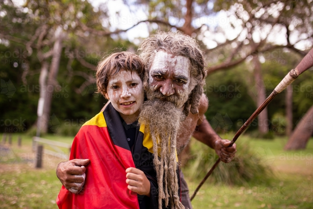 Aboriginal father and son hugging and smiling outdoors - Australian Stock Image