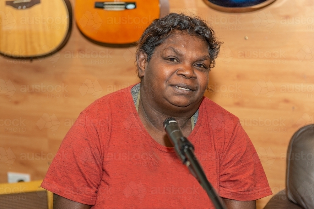 Aboriginal lady singing and playing music - Australian Stock Image