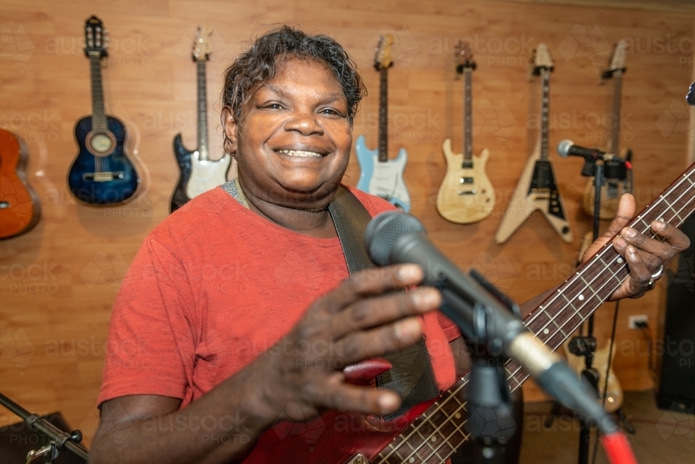Aboriginal lady singing and playing music - Australian Stock Image