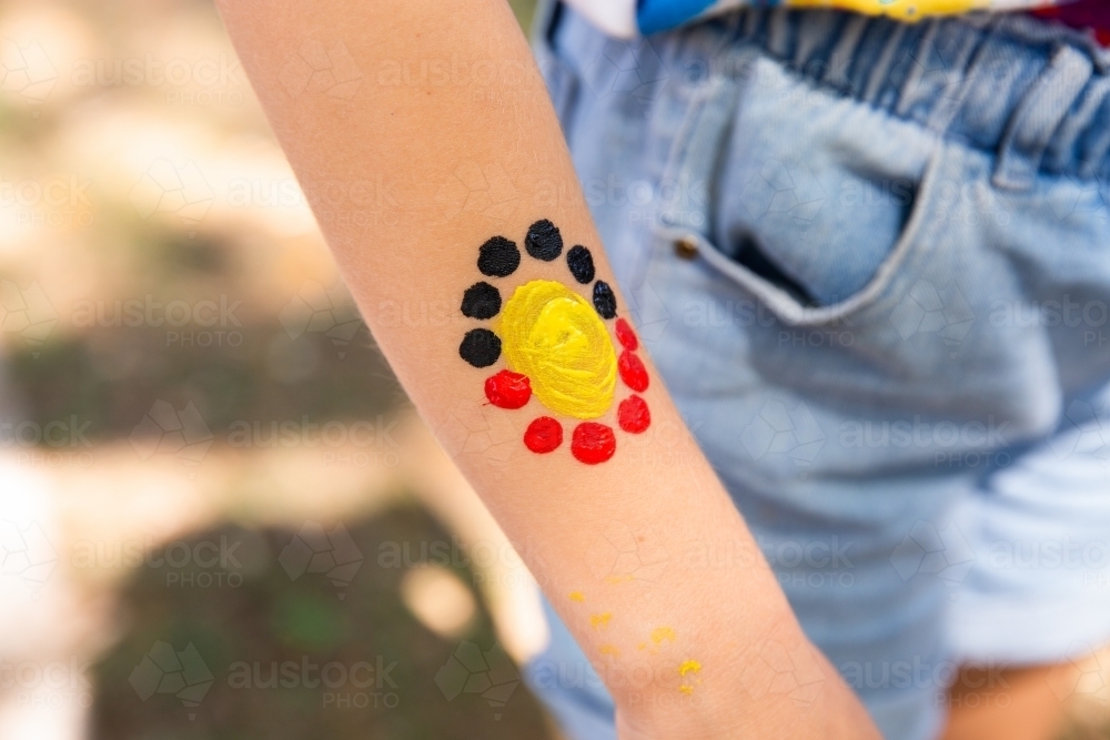 Aboriginal flag style artwork on a child's arm - Australian Stock Image