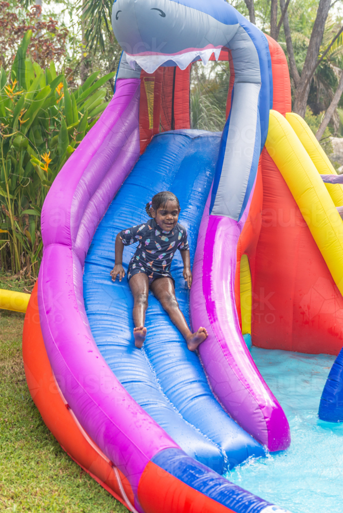 Aboriginal girl on water slide - Australian Stock Image