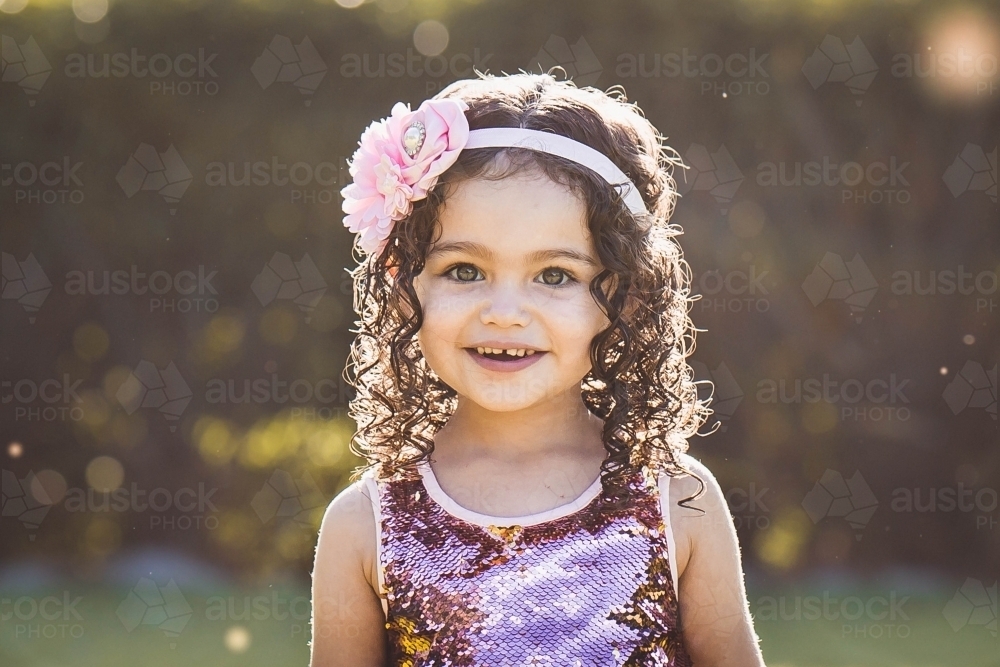 Aboriginal girl with curly hair smiling with headband - Australian Stock Image