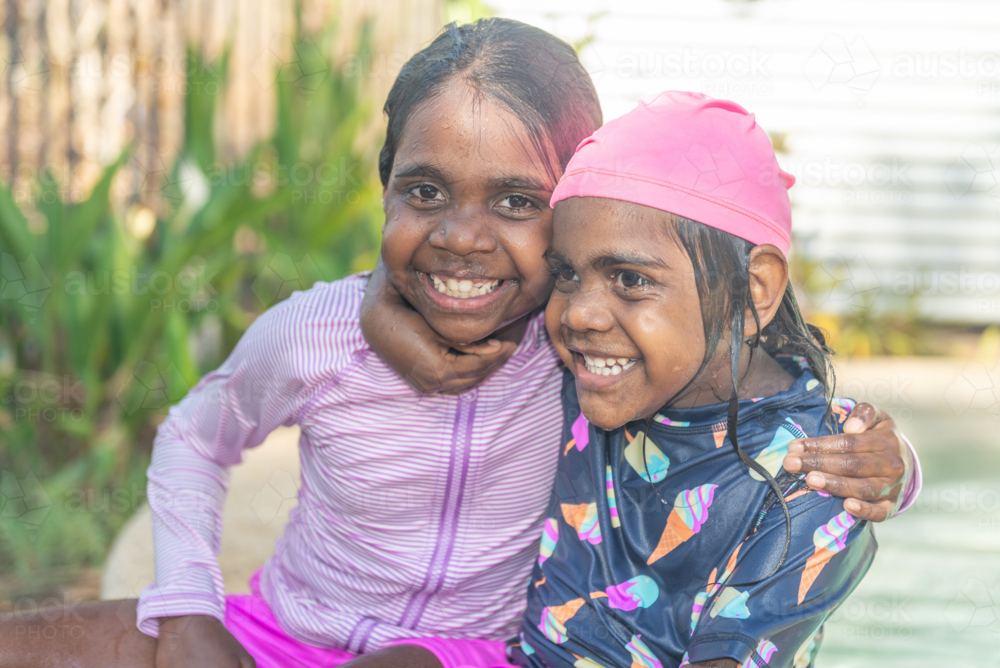 Aboriginal girls hugging by the pool - Australian Stock Image