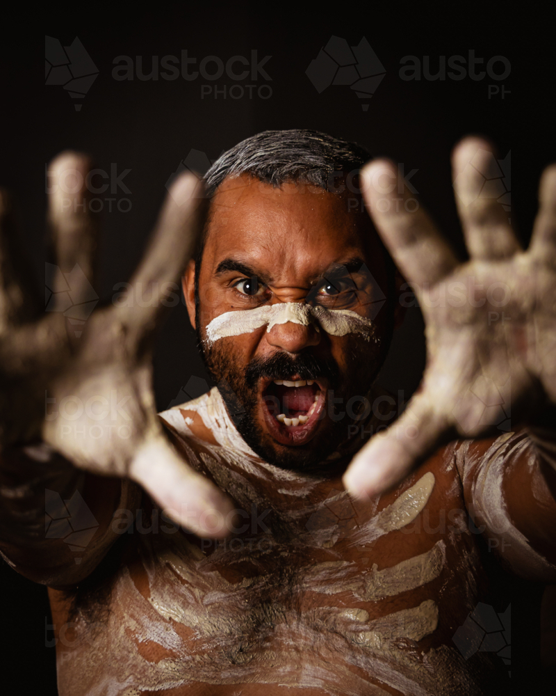 Aboriginal holding hands up yelling headshot - Australian Stock Image