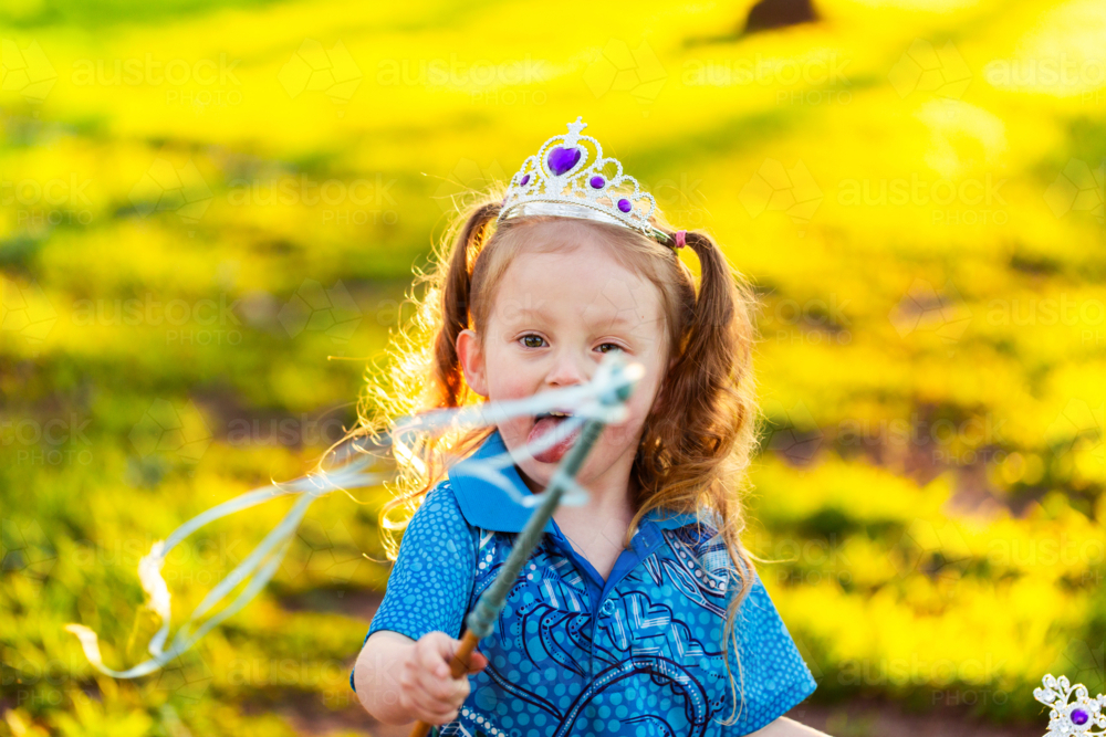 Aboriginal kamilaroi girl with princess wand and tiara playing in backyard - Australian Stock Image