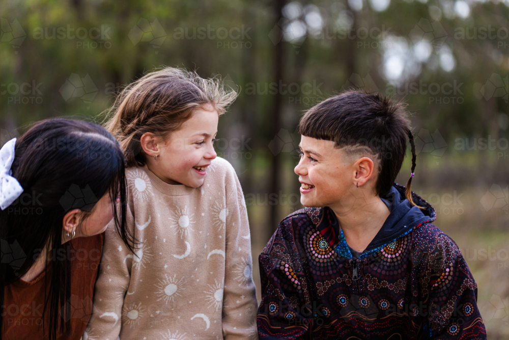 Aboriginal kids laughing and smiling together outside on overcast day - Australian Stock Image