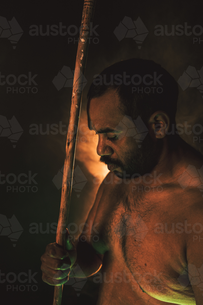 Aboriginal male with spear looking down to the side - Australian Stock Image