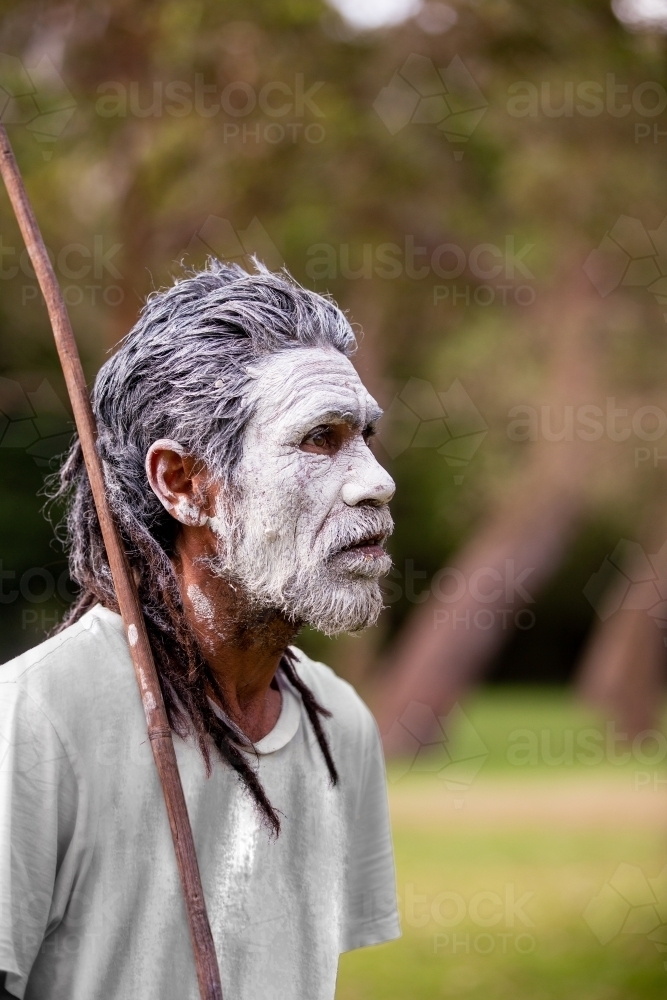 Aboriginal man in green bush surrounds telling stories - Australian Stock Image