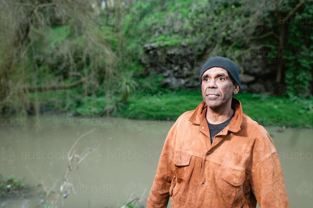 Aboriginal Man in his Forties Standing by River - Australian Stock Image