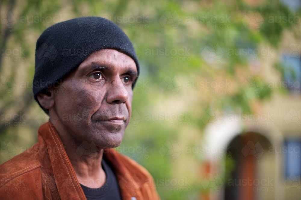 Aboriginal Man in his Forties, Tree in Background - Australian Stock Image